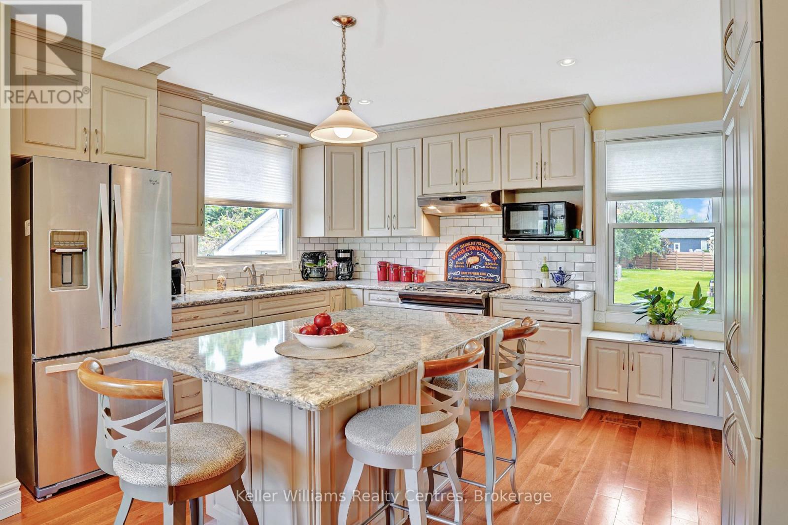 Updated kitchen with cream cabinetry and stainless appliances
