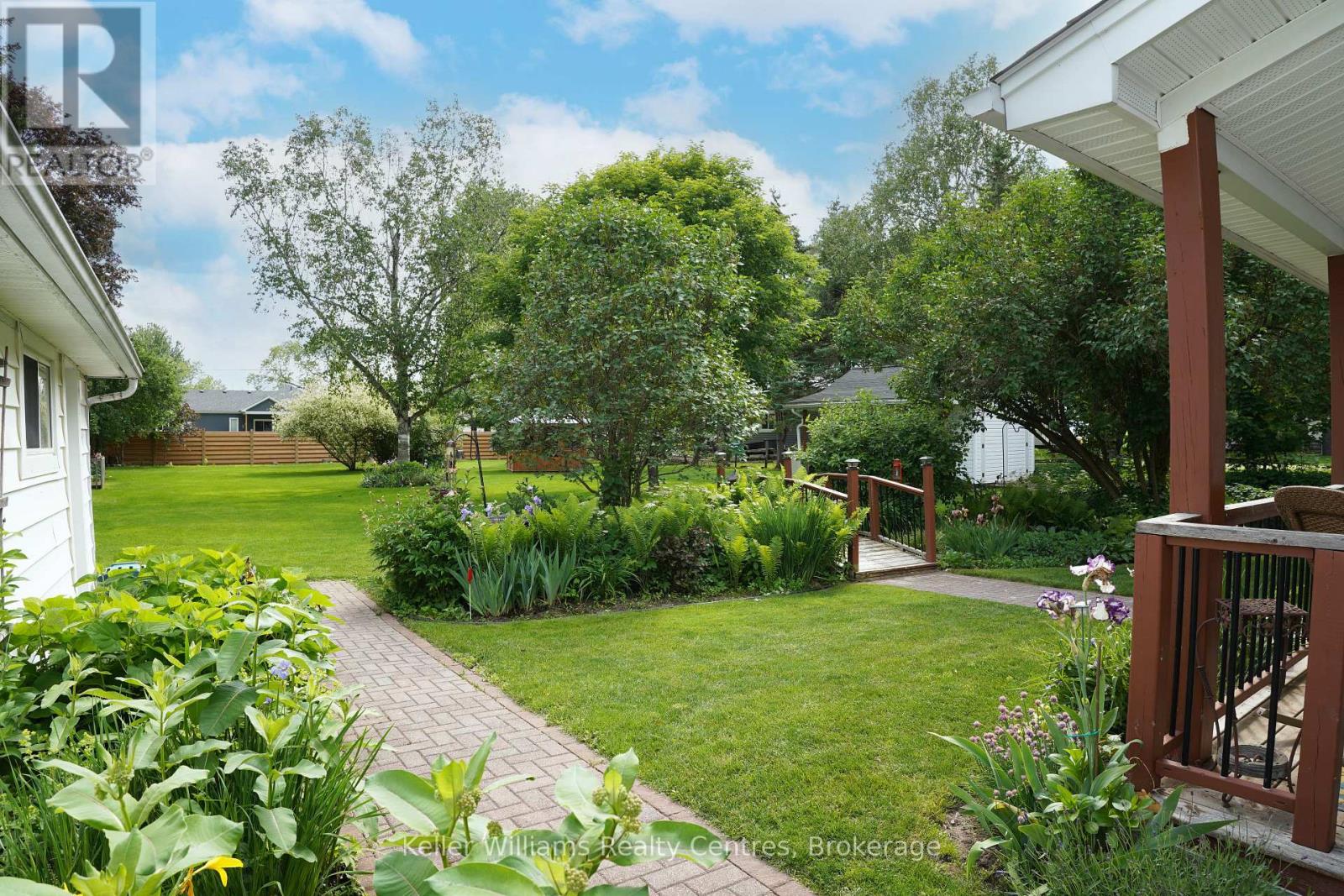 Restored back garden — paver path through perennial beds with mature trees